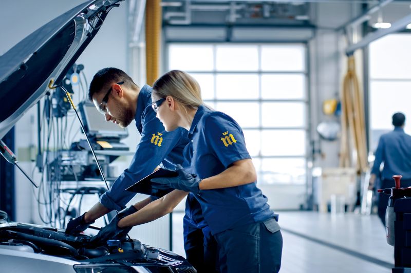 mecánicos de Midas trabajan en un vehículo